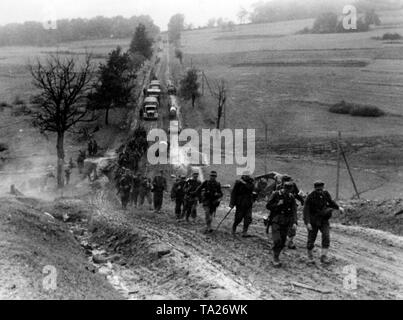 Les soldats allemands en mars la direction de l'avant sur une route boueuse dans le nord de la Slovaquie. Photo de l'entreprise de propagande (PK) : correspondant de guerre Knaack. Banque D'Images