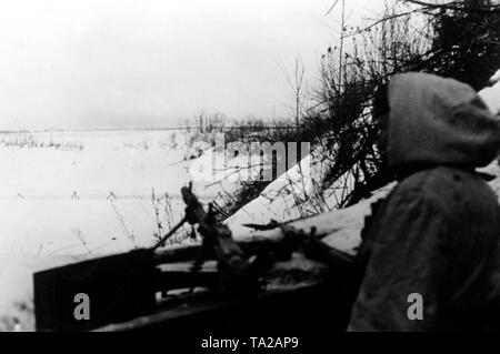 Un soldat allemand armé d'une mitrailleuse (Maschinengewehr) observe l'un des innombrables plaines au nord du front de l'Est. Photo de l'entreprise de propagande (PK) : correspondant de guerre elle. Banque D'Images