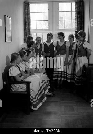 Les participants de la BDM-Fuehrerinnenschule assistent à un cours de formation en costumes. Au milieu, un membre de la jeunesse hitlérienne. Photo non datée. Banque D'Images