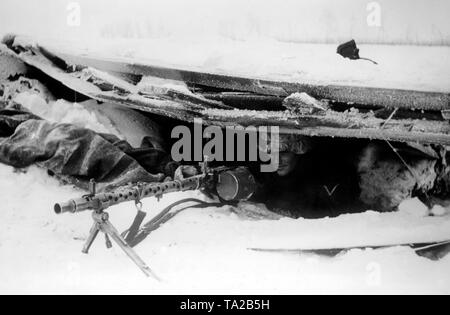 Un soldat de la Wehrmacht allemande armé d'une mitrailleuse MG 34 d'attente pour une éventuelle attaque soviétique dans un nid de mitrailleuses à Mtsensk. (Photo : PK correspondant de guerre Lachmann). Banque D'Images