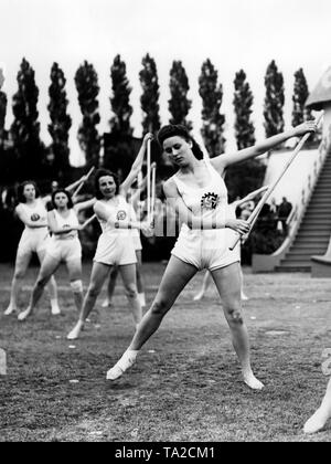 Les femmes font des exercices différents dans une compétition sportive de l'organisation Nazie "Kraft durch Freude" ('force par la joie") à la Funkturm Berlin. Ici, un baton de l'exercice. Banque D'Images