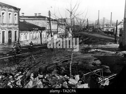 Grenadiers SS allemand dans une rue de la Kharkov. Vraisemblablement, ils sont encore dans la périphérie de la ville, comme le centre-ville est perceptible dans l'arrière-plan. Photo de l'entreprise de propagande (PK) : correspondant de guerre Zschaeckel. Banque D'Images