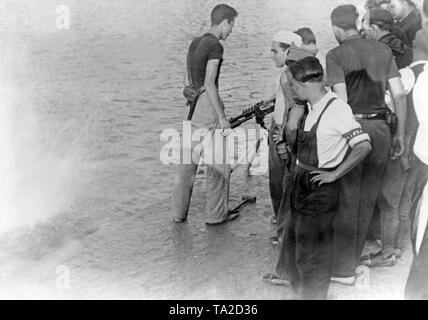 Guerre civile en Espagne, 1936 - batailles sur les îles Baléares. Photo de soldats républicains dans le port de Mahon, capitale de Minorque, au cours de la Bataille des îles Baléares peu après le début de la guerre civile dans l'été 1936.Les soldats tirer sur le quai avec une mitrailleuse Hotchkiss M1914 dans l'eau. Banque D'Images