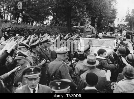 Adolf Hitler marchant dans la ville de Comme dans le territoire des Sudètes, le 3 octobre 1938. Le cortège du Hitler est reçu par la population. Ils saluent avec le salut nazi. Banque D'Images