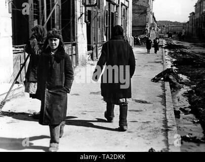 Les civils à pied à travers les rues de la ville de Kharkov, qui avait été conquis par la Wehrmacht peu avant. Un homme mort réside dans le fossé. Dans l'arrière-plan, les véhicules de la Wehrmacht. Photo de l'entreprise de propagande (PK) correspondant de guerre Mittelstaedt : Banque D'Images