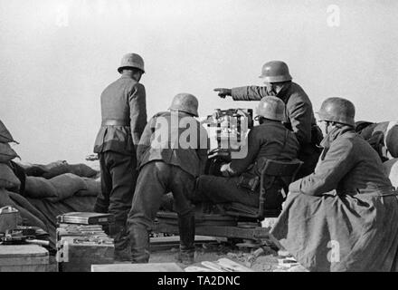 Photo non datée d'une unité antiaérienne de la légion Condor pendant le déploiement dans la guerre civile espagnole. Cinq hommes prennent visent à les cibles au sol avec un 2cm FLAK 39 dans une position en sacs. Sur la gauche de l'avant il y a des caisses de munitions. Les soldats portent des casques d'acier M35. Banque D'Images