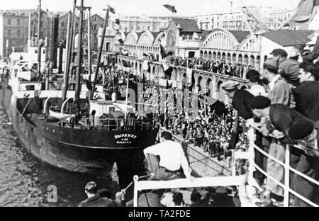 Photo du cargo soviétique SS Zyrianin (port d'Odessa) dans le Port de Barcelone. Le navire, en charge avec des bénévoles et des approvisionnements soviétiques, est reçu au quai par une foule. Banque D'Images