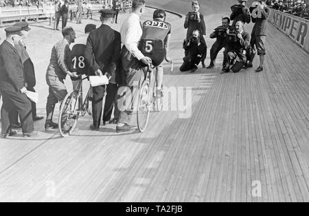 Deux voies cyclistes et leurs auxiliaires, préparez-vous pour le début d'une course à l'Ruett-Arena de Berlin. En face d'eux sont des photographes de prendre des photos. Banque D'Images