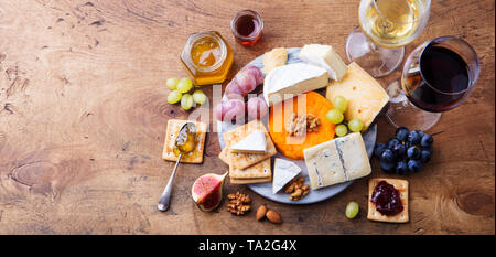 Assortiment de fromage avec du vin rouge et blanc dans les verres. Fond de bois. Vue d'en haut. Copier l'espace. Banque D'Images