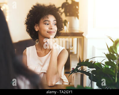 Rêver african american girl sitting in cafe et admirer le coucher du soleil Banque D'Images