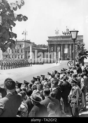 Photo de la Pariser Platz avec la porte de Brandebourg en arrière-plan pendant le défilé à l'occasion du retour de la légion Condor de la guerre civile espagnole le 6 juin 1939. Au premier plan, les piétons se tenant sur le bord de la route. Les soldats marchent dans l'Unter den Linden Strasse vers l'Est en direction de Lustgarten. Banque D'Images