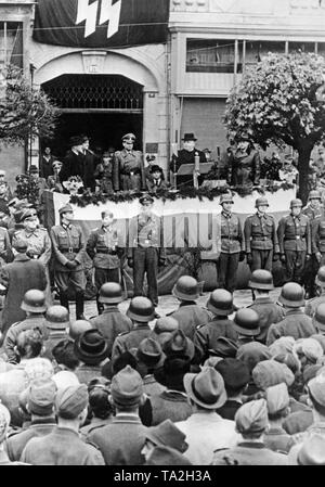 Président de la Première République Slovaque Jozef Tito prononce un discours avant de grenadiers à la place du marché de Banska Bystrica. Dans l'arrière-plan, un drapeau nazi de la Schutzstaffel (escadron de protection). Six mois après l'accord de Munich, Hitler a occupé le reste de la Bohême et de la Moravie, et la première République slovaque a été fondée sur son commandement. Banque D'Images