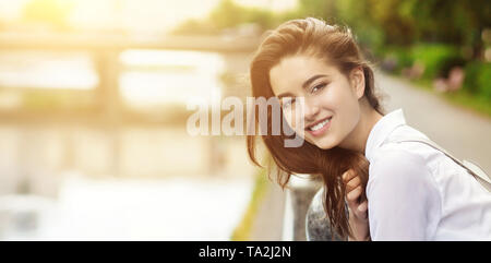 Gorgeous woman admire le coucher du soleil dans le parc et smiling Banque D'Images