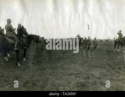 Les membres de la "Division de fer" des Freikorps, un bénévole unité formée d'Allemands et Allemands baltes au cours de la guerre de l'indépendance balte, défiler devant leurs commandants et officiers, dont le commandant de l'Armée de libération russe Ouest Prince Pavel Bermondt-Avalov (extrême gauche avec les Cosaques) et le commandant en chef de toutes les troupes allemandes dans les pays baltes, le général Ruediger von der Goltz (à gauche avec casque à pointe). Banque D'Images