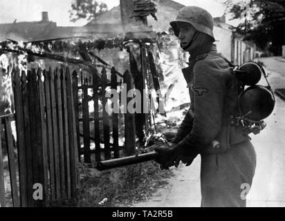 Soldat allemand avec un lance-flammes 41 est une maison en feu à l'avant. L'pictutre est probablement tourné à Varsovie ou dans la zone pendant le soulèvement par corrospondent Könnecke accrédités (propagande) de l'entreprise. Banque D'Images