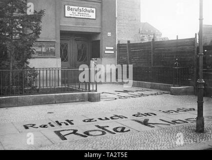 Communistes peint un slogan sur le trottoir en face d'une école professionnelle pour jeunes filles dans le quartier berlinois de Wilmersdorf. L'appel est : 'May 1ère grève de l'école. Entrer dans la classe rouge !' Banque D'Images