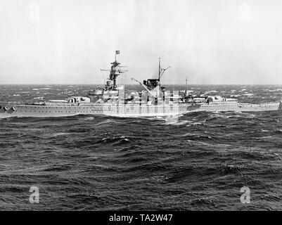 Photo du croiseur lourd « Deutschland dans une mer agitée prises par un photographe de la flotte de l'organisation Nazie "Kraft durch Freude" ('force par la joie") au cours d'un voyage au large de la KdF côte italienne le 7 novembre, 1937. L'équipage a aligné sur le pont. À l'avant et à l'arrière il y a deux tourelles de 28 cm avec six canons à tir rapide. Au milieu, l'un des deux navires du type avions Arado Ar 196. Banque D'Images