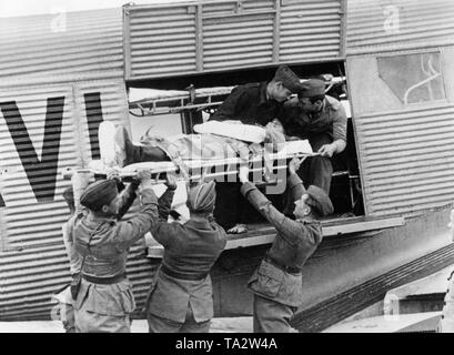 Photo d'un soldat blessé de la légion Condor, est transporté par des camarades sur une civière à une ambulance d'air (Junkers Ju 72) de la Lufthansa allemande pour le transport vers un hôpital en Allemagne. Banque D'Images