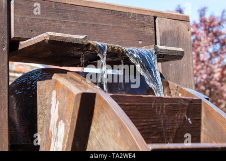 Grande roue en bois qui tournent avec piscine d'eau libre aux beaux jours Banque D'Images