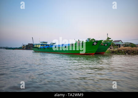 CAN Tho, Vietnam - 27 mars 2019 : nouvelles barges cargo sur la rive. Marché Flottant dans le Delta du Mékong. Les bateaux de commerce/le fleuve Mékong en croisière. Maisons sur stil Banque D'Images