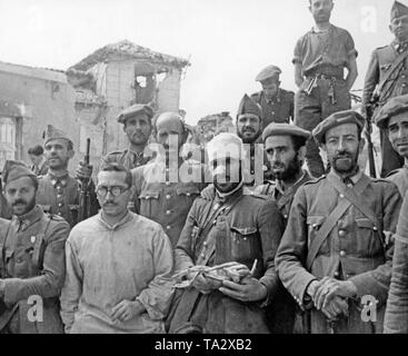Photo d'un groupe de soldats de la Guardia Civil, après sept semaines de siège de l'Alcazar de Tolède après sa libération le 26 septembre 1936. Au centre, un homme blessé est titulaire d'un poulet déplumé. Banque D'Images