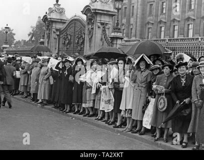 Les gens attendent sur le bord de la route devant le palais de Buckingham à Londres. Le Premier ministre britannique revient de Munich, et des lecteurs pour le monarque britannique. Un accord a été conclu avec Hitler à Munich. C'était censé l'annexe les Sudètes à l'Empire allemand sans commencer une guerre. Banque D'Images