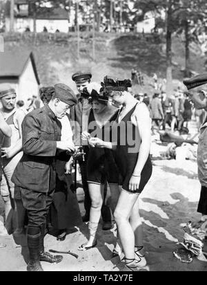 Deux femmes en costumes de bains parler avec un soldat américain en uniforme dans la piscine en plein air de Wannsee. Banque D'Images