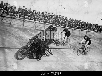 Deux voies cyclistes roulent avec leurs pacers motorisé sur la Olympiabahn à Berlin dans le cadre de l'ouverture de la piste et le prix de Pâques. L'un des deux conducteurs est dépassé. Son pacer est de le regarder. Banque D'Images