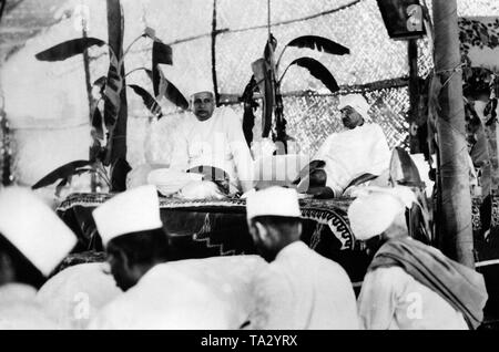 Le chef du mouvement nationaliste indien Mahatma Gandhi (à droite), préside une conférence de chercheurs. À côté de lui est l'industriel et freedom fighter Seth Jamanlal Bajaj. Banque D'Images