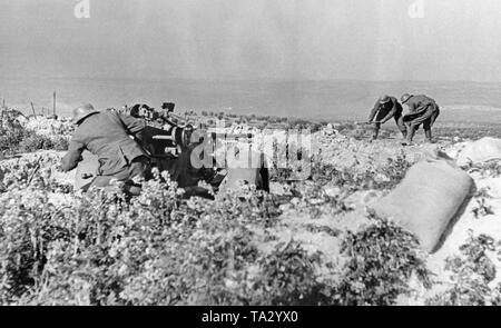 Photo de deux mitrailleurs allemands de la légion Condor, qui sont à démolir un mur à Tolède, au cours d'une des dernières batailles de la guerre civile espagnole. Leur but est de viser un libre avec les 2cm FLAK 30 à les positions ennemies dans l'arrière-plan. Banque D'Images