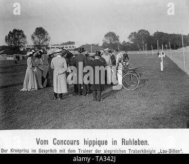 Le Prince Wilhelm (4e derrière la voiture) après la course en conversation avec l'entraîneur de l'équipe gagnante mare 'Lou-Dillon'. Crown Princess Cecilie (3e à partir de la gauche) était également présent à la course de chevaux. Elle caresse la tête de jument pendant la conversation de son mari. Banque D'Images