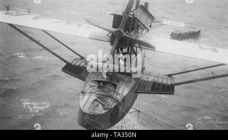 L'hydravion 'Numancia' avec la queue numéro M-Mwap est poussé à bord du HMS Eagle. Dans l'arrière-plan dans un bateau de sauvetage sont pilotes espagnols qui ont été secourus par l'équipage de l'Aigle. Le 22 juin 1929, le pilote Espagnol Ramon Franco a échoué avec la tentative de traversée de l'Atlantique et a été sauvé sept jours après l'atterrissage d'urgence en eau par le porte-avions britannique HMS Eagle. Banque D'Images