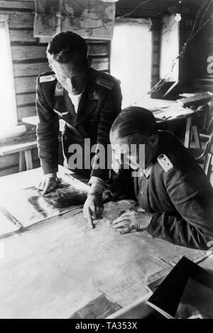 La Luftwaffe contrôleur aérien avancé (à gauche), ici un lieutenant, présente un officier d'état-major général, ici un colonel, des photographies aériennes de la reconnaissance. La photo a été prise à Gurodez, septembre 1941, sur le front de l'Est. Photo : reporter de guerre Ulrich. Banque D'Images