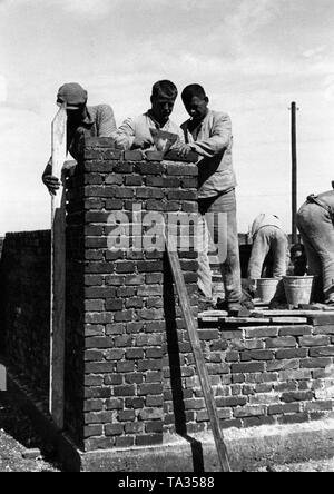 Détenus dans le camp de concentration de Dachau la construction d'un mur. Cette photo, tout comme beaucoup d'autres, a été faite pour des fins de propagande nazie. Banque D'Images