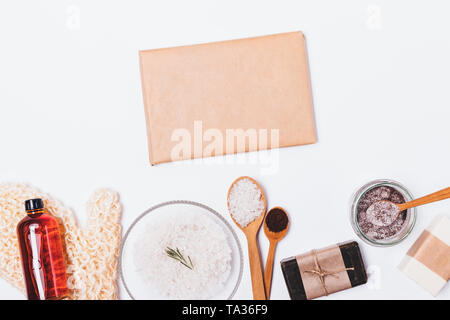 Vue de dessus case vierge enveloppé dans du papier brun près d'accessoires de bain et cosmétiques naturels pour le nettoyage de la peau et l'exfoliation sur fond blanc. Banque D'Images