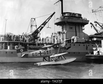 Au cours d'une revue navale à Swinemuende, le croiseur 'Nuremberg' prend une embarcation à bord avec sa grue. L'aéronef est un Heinkel He 60. Banque D'Images