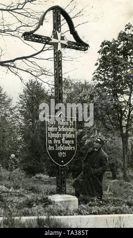 Un homme regarde le mémorial pour les morts Freikorp des soldats de l'insurrection polonaise en Haute Silésie. En vertu de la croix de Malte, suivant l'ordre "Pour le Mérite', est un signe avec l'inscription 'ici reste 21 brave Selbstschutz (auto-protection) combattants, tombé dans les jours de l'insurrection de 1921". Banque D'Images