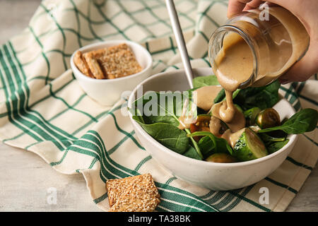 Coulée de tahini savoureux de ci sur les légumes frais dans un bol Banque D'Images