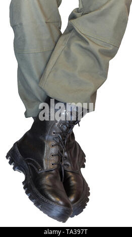 Jambes croisées en pantalon kaki de l'armée militaire et des bottes noires isolé sur fond blanc Banque D'Images