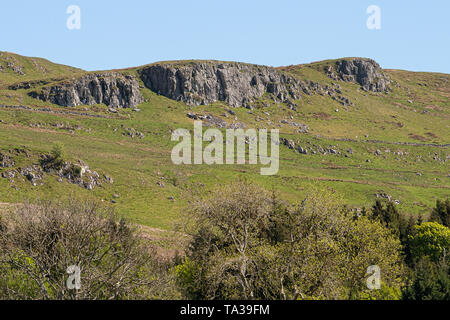 Colline de roches pourrait derrière la ville de Largs Ecosse à Ayrshire typique sur les terres agricoles avec les jeunes agneaux, arbres et haies dans la distance agai Banque D'Images
