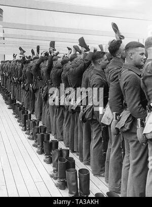 Photo de soldats de la légion Condor revenant d'Espagne, à bord de la Kraft durch Freude (organisation Nazie "force par la Joie) le navire à vapeur 'Robert Ley'. Ils sont accueillis par les spectateurs à l'Elbstrand en entrant dans le port de Hambourg le 30 mai 1939. Derrière les soldats, leurs bottes de marche, qu'ils vont mettre sur après l'atterrissage. Banque D'Images