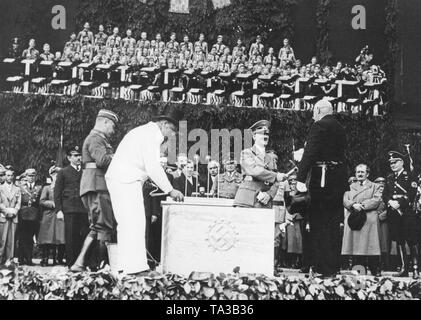 Poser la première pierre de l'usine Volkswagen de la 'Stadt des KdF-Wagens" (Ville de la voiture KdF), maintenant Wolfsburg. Hitler reçoit la première pierre marteau de l'contremaître maçon. Banque D'Images