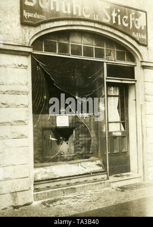 Un homme regarde à travers la vitrine brisée de la Laipe magasin de chaussures. La vitrine a été pillé probablement pendant les troubles à Berlin. Banque D'Images