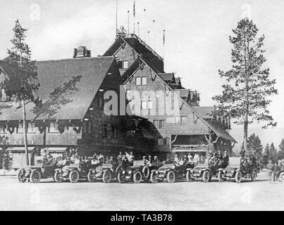 Location de touristes avec leurs voitures dans le Parc National de Yellowstone en face de l'hôtel de luxe "Old Faithful Inn". Banque D'Images