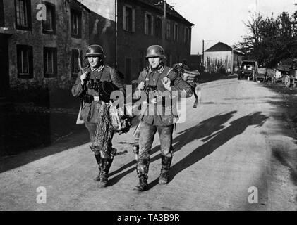 Deux sous-officiers allemands dans une ville française qui remplis d'souvenirs de guerre, entre autres. Un casque d'acier et d'un képi de police (à gauche). Notez également les grenades à main mise dans les bottes. Banque D'Images