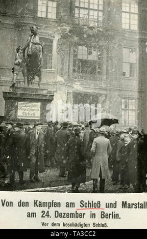 Les spectateurs en face de la destruction du portail central de la Ville Impériale Palace à Berlin Mitte. Sur la gauche est un cheval statue, sur la base de ce qui est le cas d'une plaque avec l'inscription "socialisme & Travail". Le dommage est causé par les combats entre les forces gouvernementales et les membres de la Volksmarinedivision. Banque D'Images