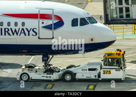 L'aéroport de London Gatwick, Angleterre - Avril 2019 : l'aéroport remorqueur repoussant un British Airways Airbus A319 jet Banque D'Images