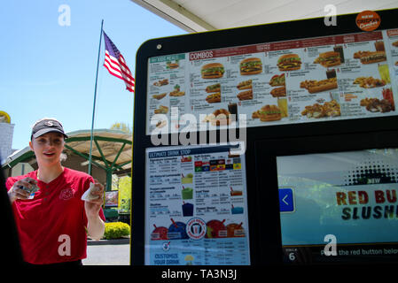 Wallingford, CT USA. Mai 2019. Un fast food Sonic jeunes femmes carhop desservant rapidement condiments aux clients dans les voitures au ciné-parc. Banque D'Images