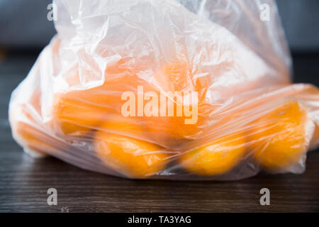 Mandarines acheté dans le supermarché dans un sac en plastique à usage unique de produire. Pas l'environnement. Beaux fruits orange, aucune marque visible. Banque D'Images