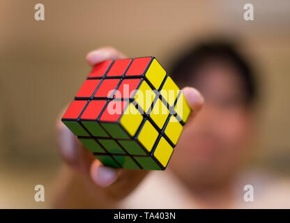 Résolu ! Un homme tenant un rubik's cube résolu. Banque D'Images